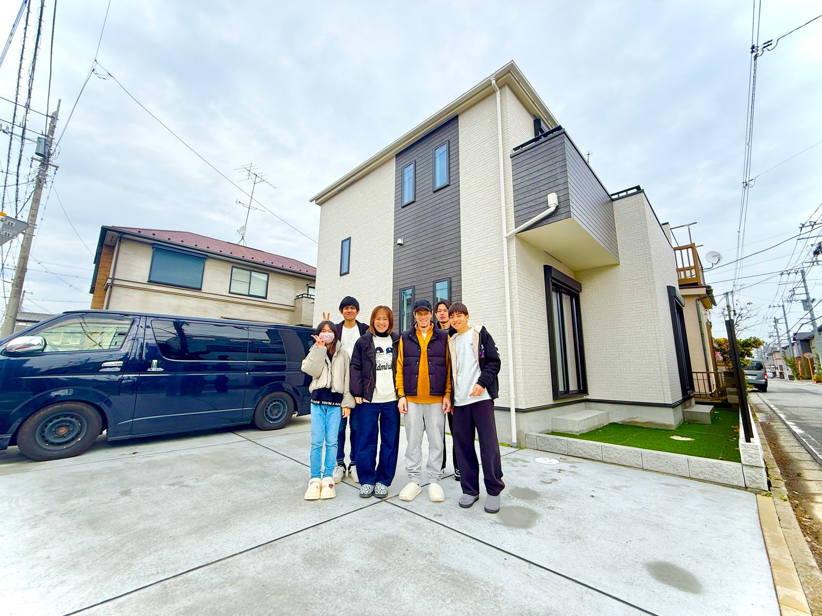 新築戸建ての前に集まるご家族