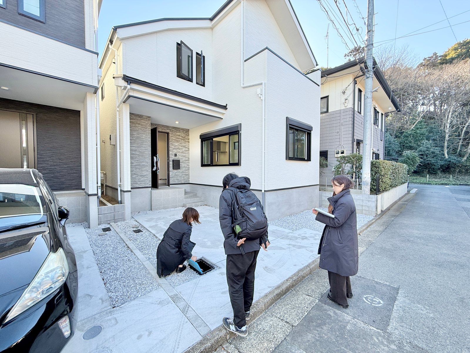 新築戸建ての外まわりを確認するお客さまとスタッフ
